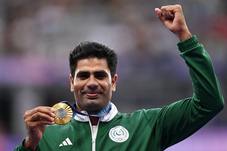 Arshad Nadeem celebrates on the podium during the victory ceremony