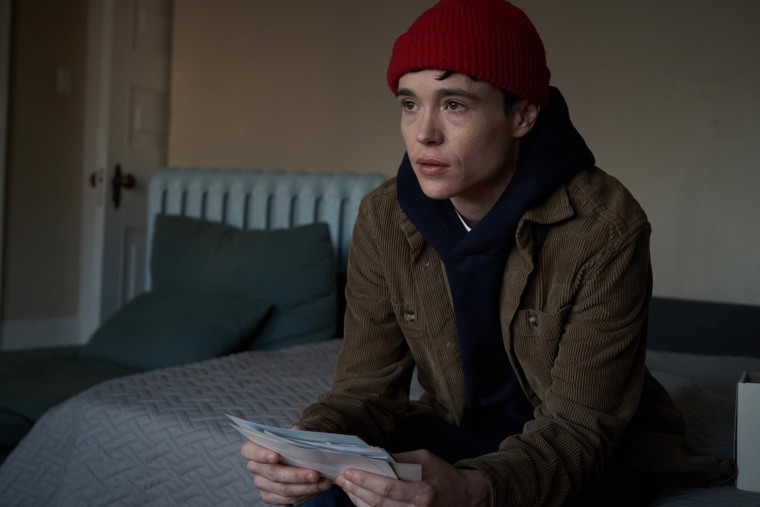 Elliot Page sitting on bed holding papers in recent film 'Close to You.'