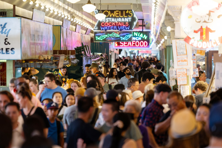 A large crowd of shoppers walking around the market