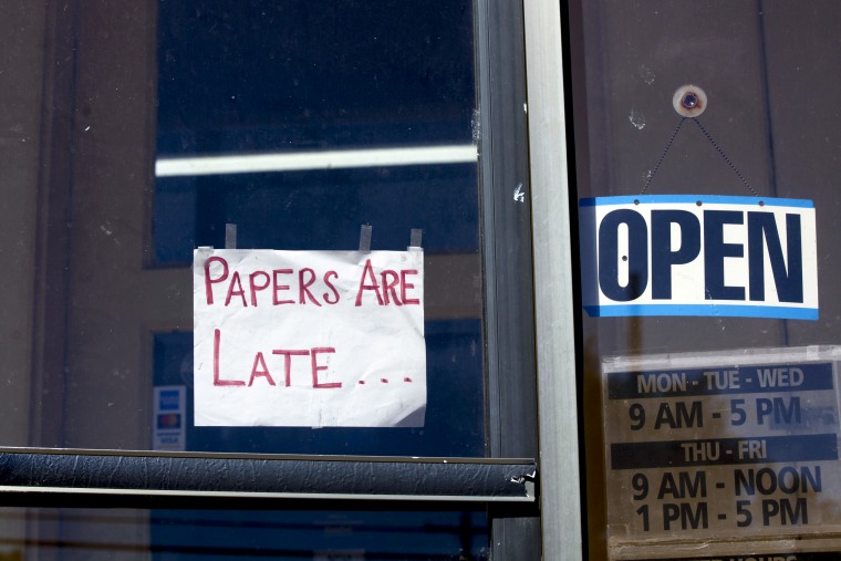 A handmade sign on a door of the Marion County Record that reads "PAPERS ARE LATE..."