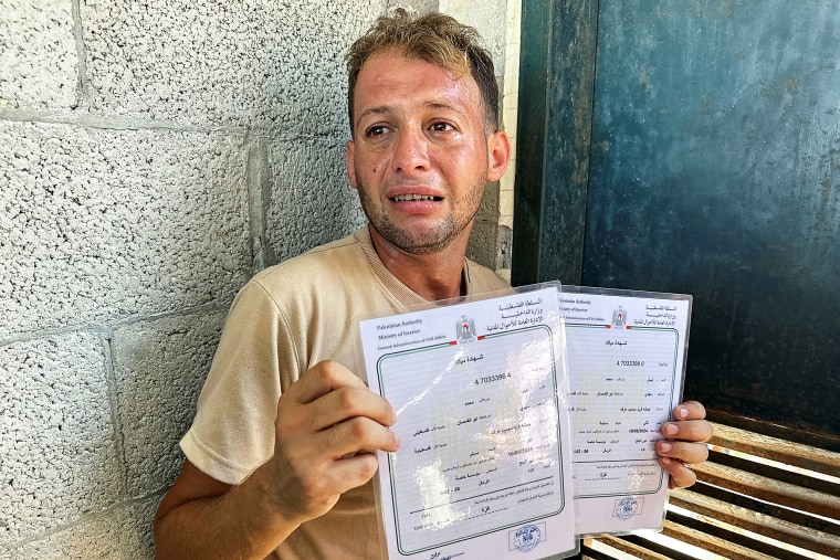 Palestinian father mourns twins killed in an Israeli strike while bringing their birth certificates 