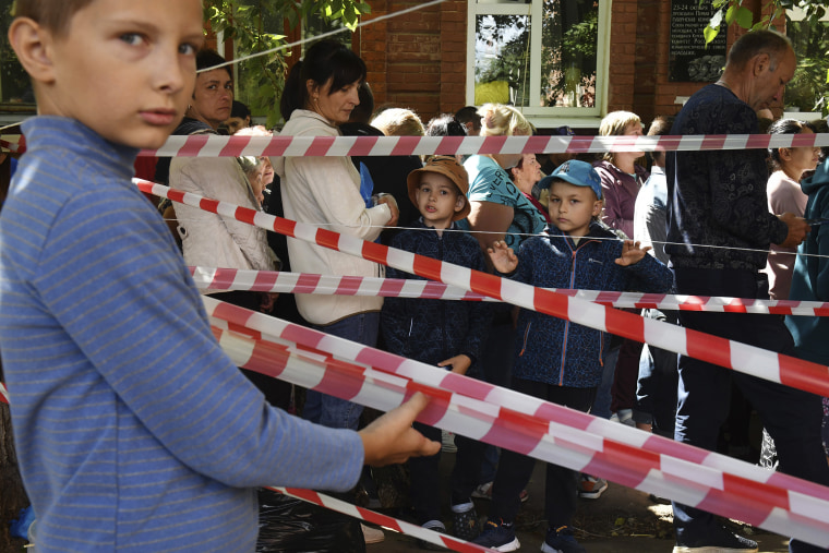 People evacuated from fighting between Russian and Ukrainian forces queue to receive humanitarian aid at a distribution center in Kursk, Russia, on August 12, 2024.