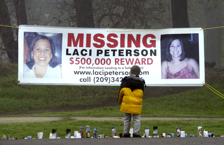 A young child looks at a makeshift memorial and a missing persons banner offering a $500,000 reward for information about Laci Peterson in Modesto, Calif., on Jan. 4, 2003. 