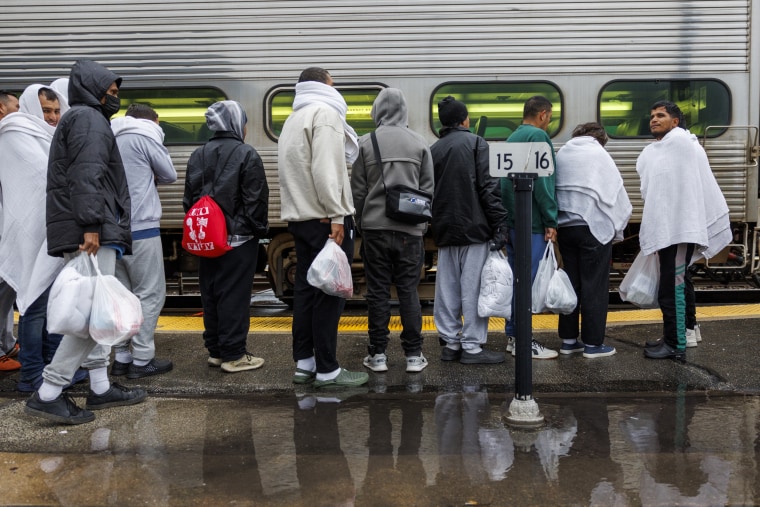 Migrants board a Wilmette Metra train to Chicago after traveling by bus from El Paso