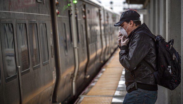 Commuter wears face mask while waiting for train on Long Island 