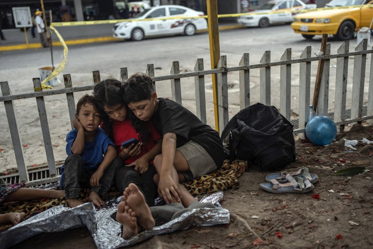 As crianças Bolaños, da esquerda para a direita, Sebastian, Kamila e Miguel Angel, da Venezuela, do lado de fora do terminal de ônibus onde vivem com sua mãe solteira, em Villahermosa, México, em 8 de junho de 2024. 