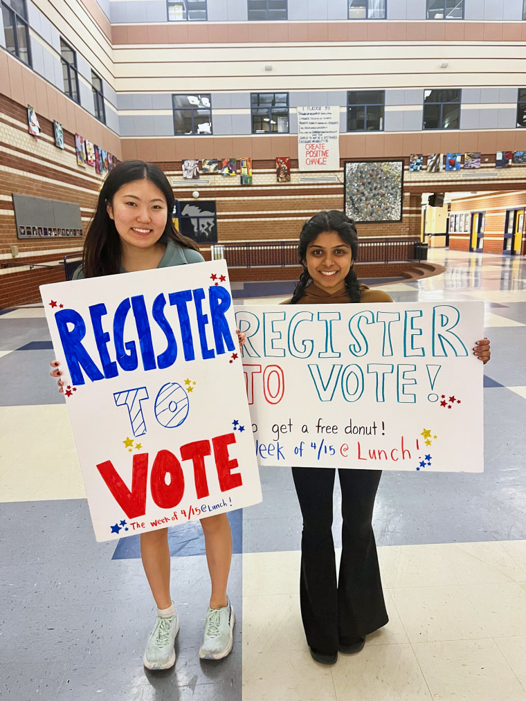 Jessie Cai holds up a sign that reads: "Register to vote"