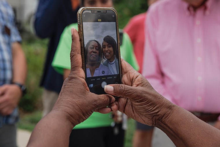 Angela Alsobrooks takes a selfie with someone, the phone screen can be seen