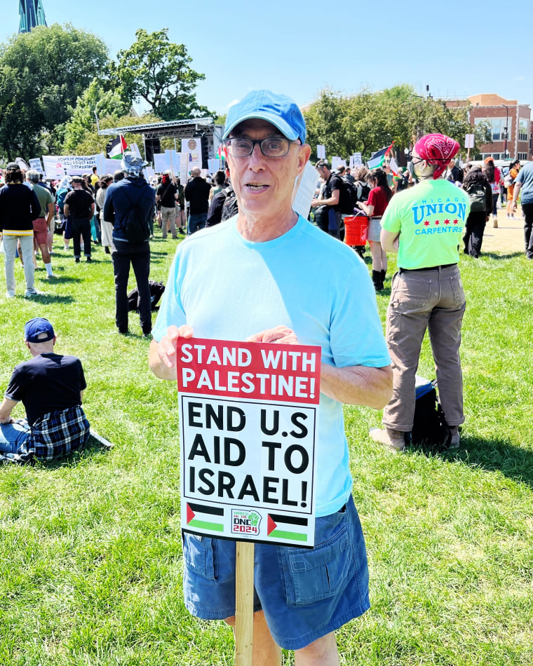 Fred Schein holds a sign that reads, "Stand with Palestine! End US Aid to Israel"