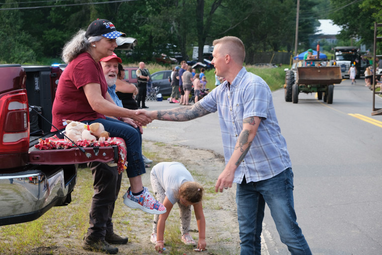 Jared Golden shakes hands with Linda Ross outside next to her red pickup truck