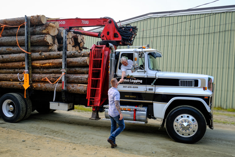 Jared Golden shakes hands with a person inside of a logging truck