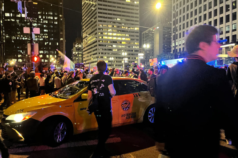 A taxi with passengers got stuck in the crowd.