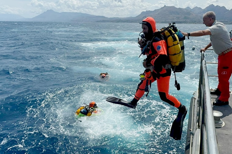 Divers operate in the sea to search for the missing after a luxury yacht sank off Sicily