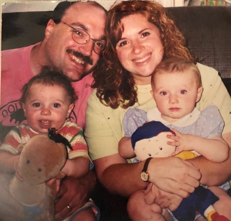 Father and mother holding their twin babies 