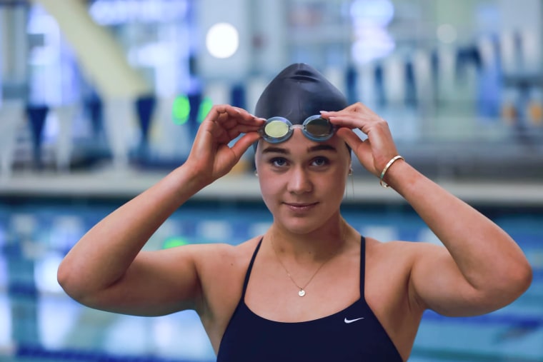 Ali Truwit lifts up her swimming goggles by the pool