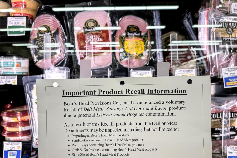 A recall notice hangs next to Boar's Head meat in a grocery store.