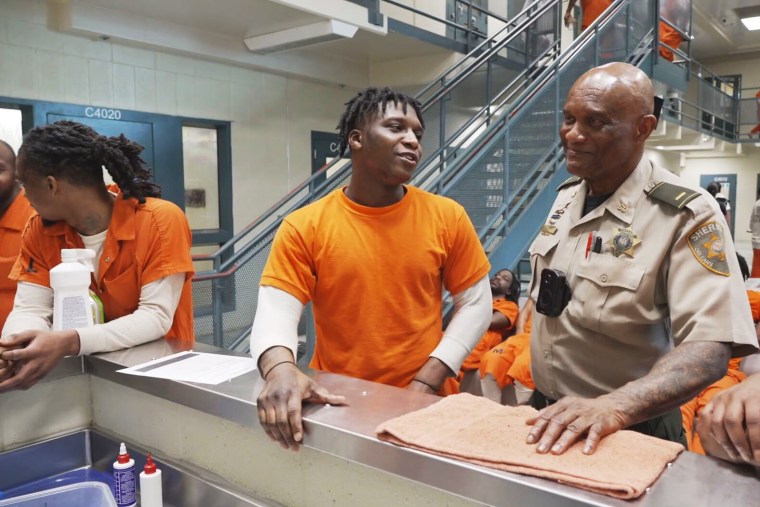 Lieutenant Michael Lewis jokes around with members of a new mental health community inside the New Orleans jail. 
