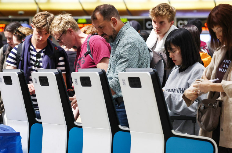 Travelers use kiosks in the international terminal at Los Angeles International Airport.