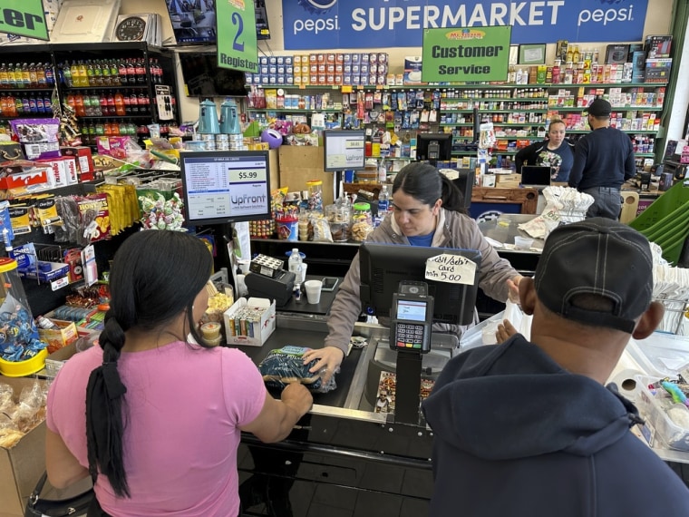 La cajera Rosa Dilone ayuda a los clientes en el supermercado Mi Tierra en Hazleton, Pennsylvania, el 16 de mayo de 2024. 