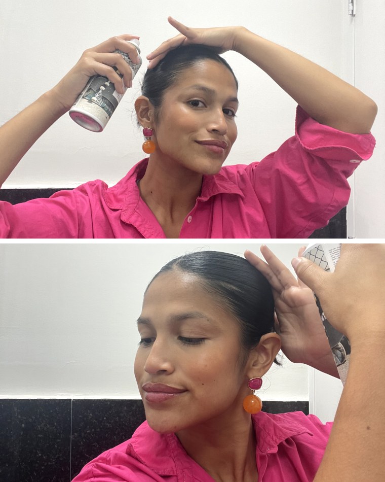 Woman sprays R+Co Halfpipe Spray on her bun up-do.