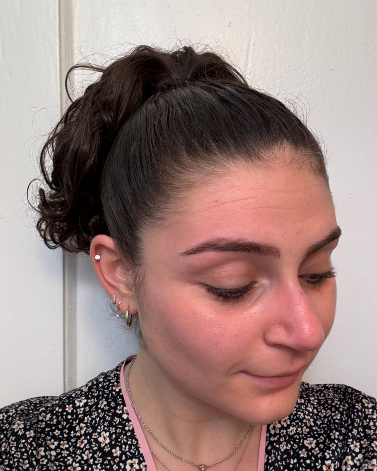 Woman shows a frizz-free curly up-do after using the wax stick.