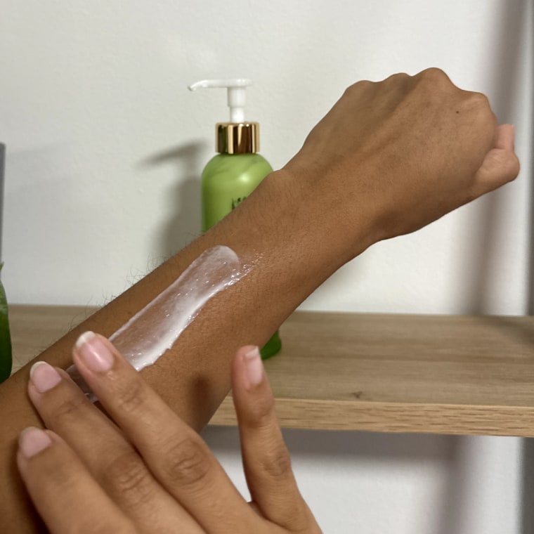 Woman swatches the Tata Harper Resurfacing Body Serum onto her left arm.