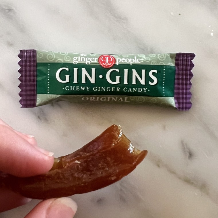 One wrapped and one unwrapped Gin Gins ginger chew on a marble table