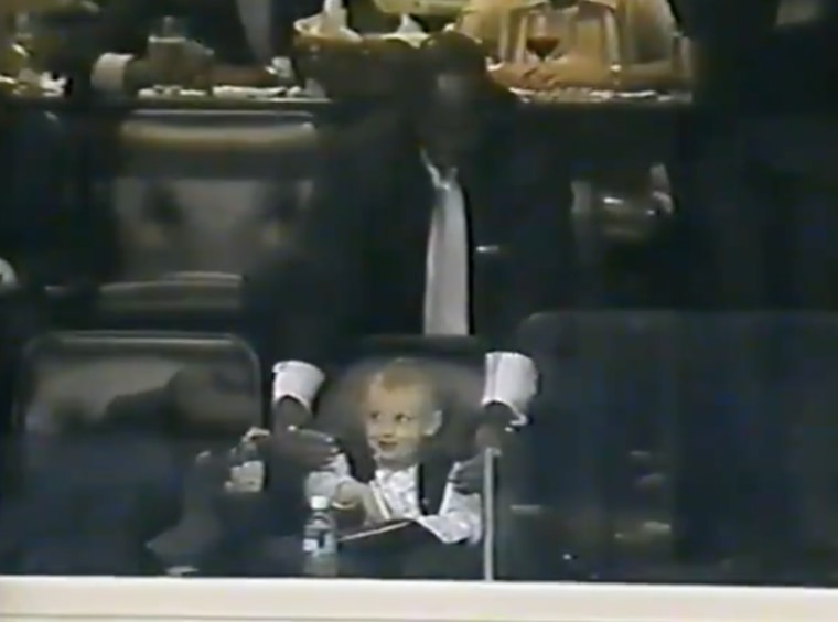 A baby Katie Ledecky cracks a smile as Michael Jordan plays peekaboo with her in the stands.