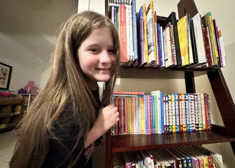 My daughter, Mila, proudly shows off our book collection.