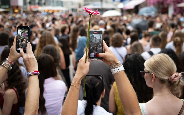 Taylor Swift fans take photos and sing together on Stephansplatz in Vienna, Austria.