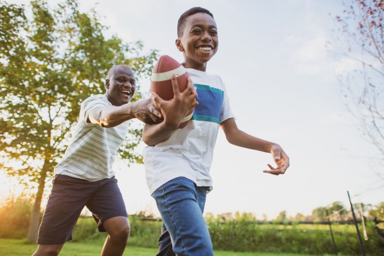 Father and son playing backyard football.