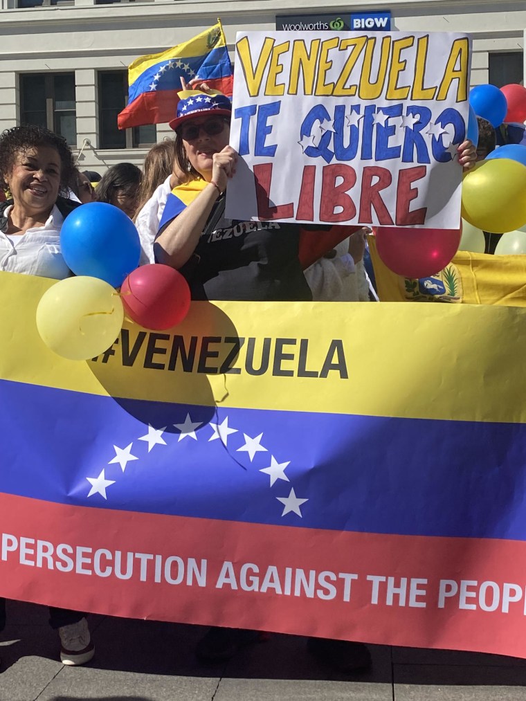 Venezolanos sostienen banderas y carteles durante una protesta este sábado en el centro de Sydney, Australia.