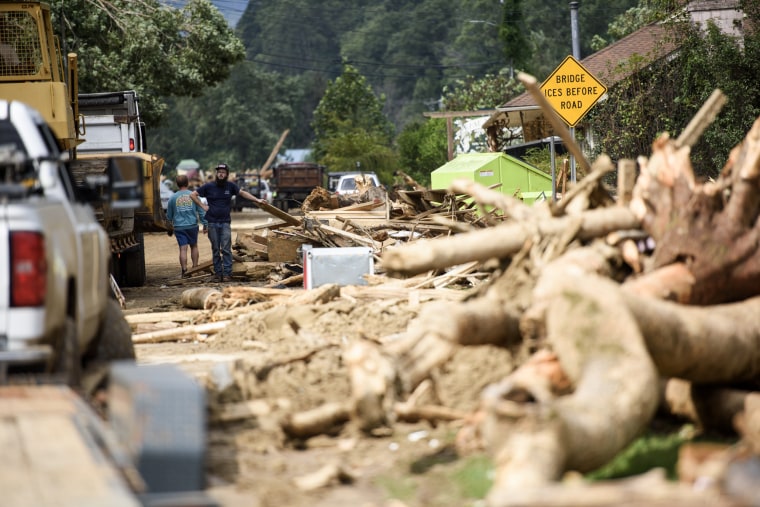 People navigate through debris after the Rocky Broad River flowed into Lake Lure overflowing the town with debris after heavy rains from Hurricane Helene  on September 28, 2024 in Lake Lure, N.C.