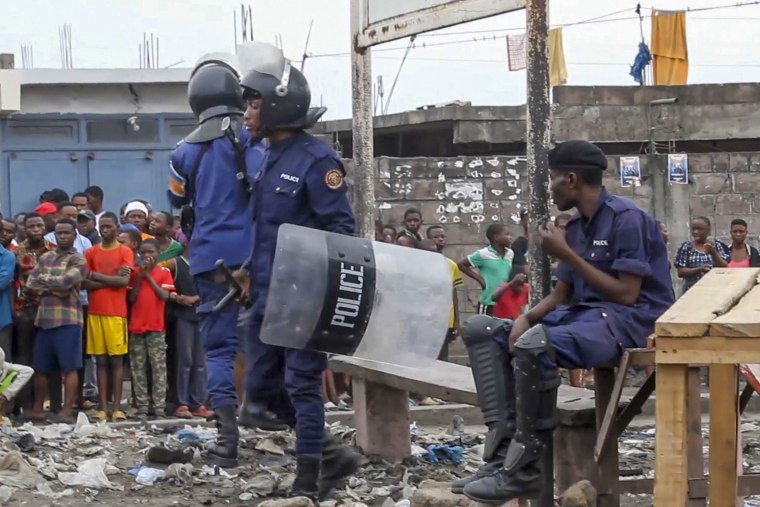 Police officers outside Makala prison while bystanders watch.