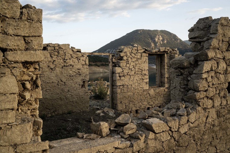 From beneath the shrinking Lake Mornos in central Greece, the muddied remains of homes are reemerging nearly 45 years since the village that once stood here disappeared underwater.