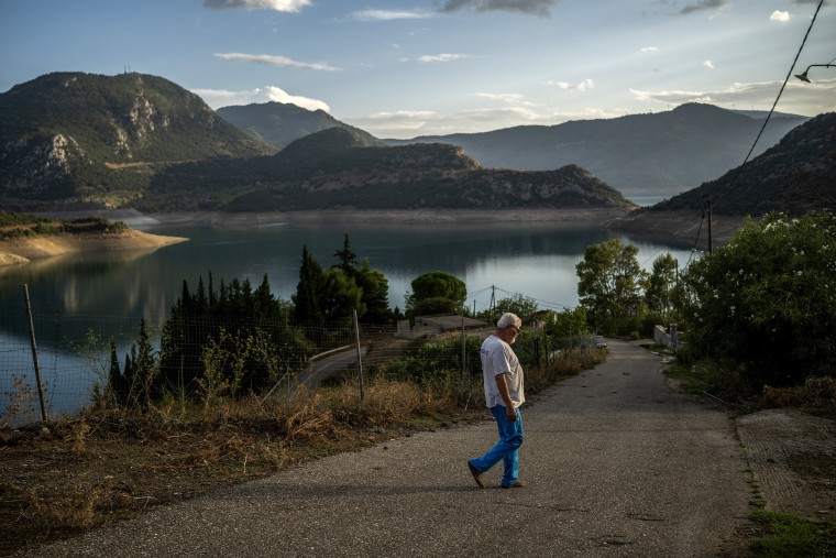 Yiorgos Iosifidis, a pensioner, who lives in newly rebuilt houses in Kallio, walks past Mornos artificial lake, near the village of Lidoriki, about 240 km northwest of Athens, on September 1, 2024.