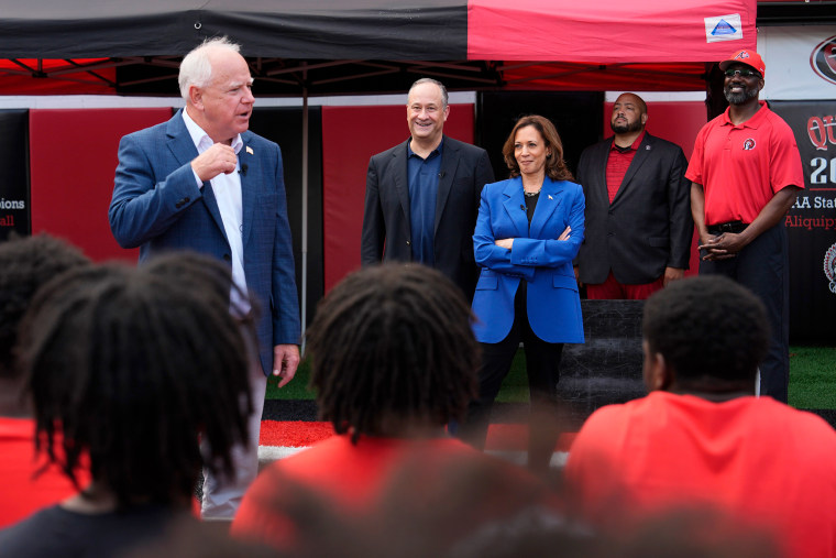 Image: tim walz kamala harris doug emhoff campaign stop football team high school players politics political politicians