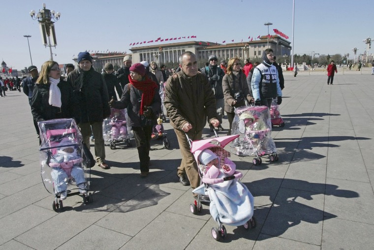 Spanish couples take their newly adopted Chinese children for a walk in Beijing's Tiananmen Square, March 7, 2007.