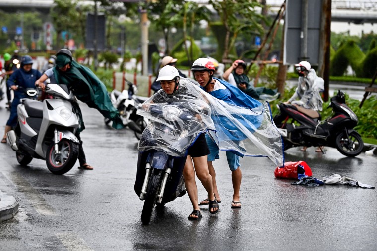 Os motociclistas lutam contra o vento forte.