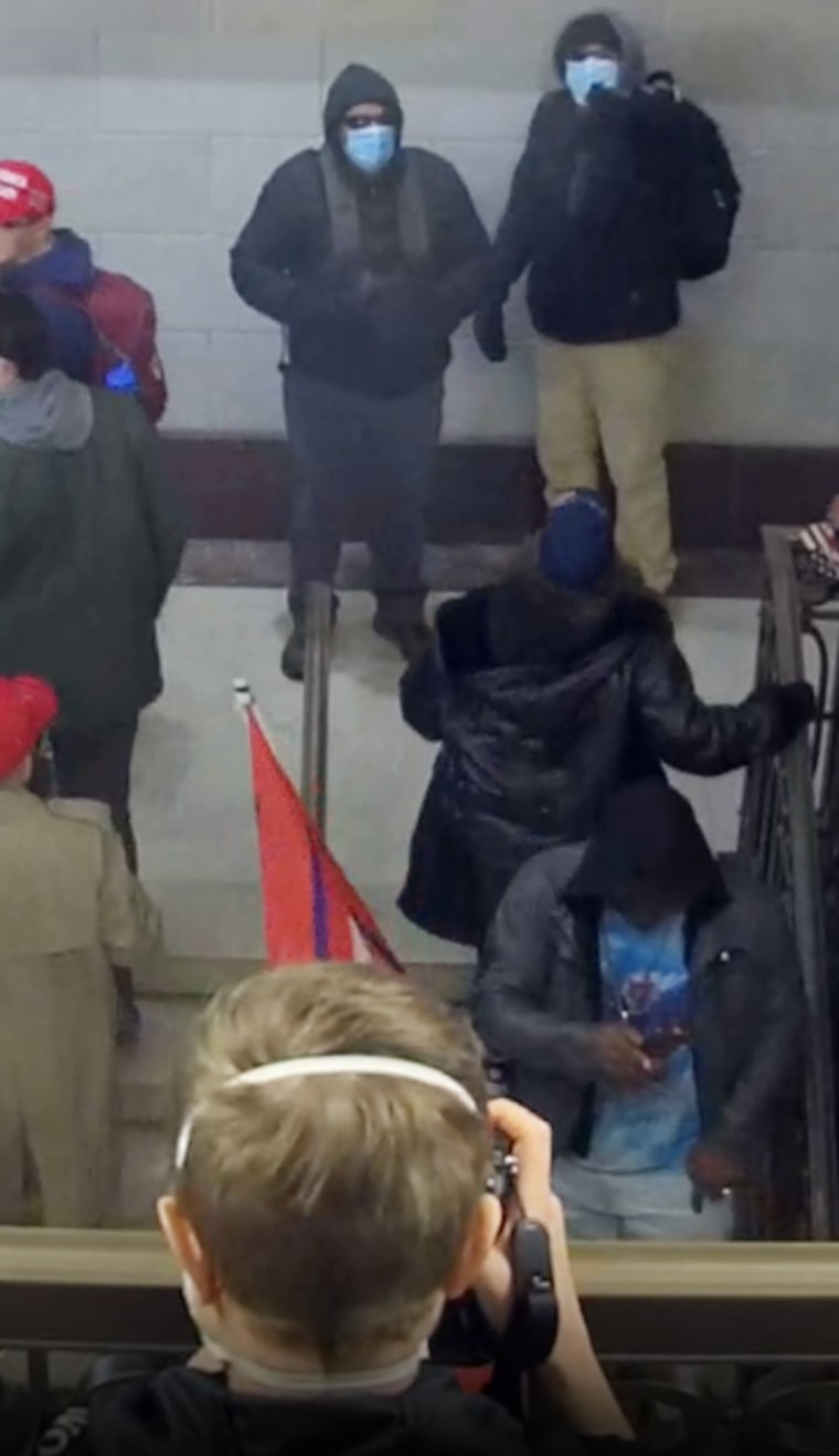 The men the FBI identified as the Walker brothers, as seen pointing at a New York Times photographer before her assault. 