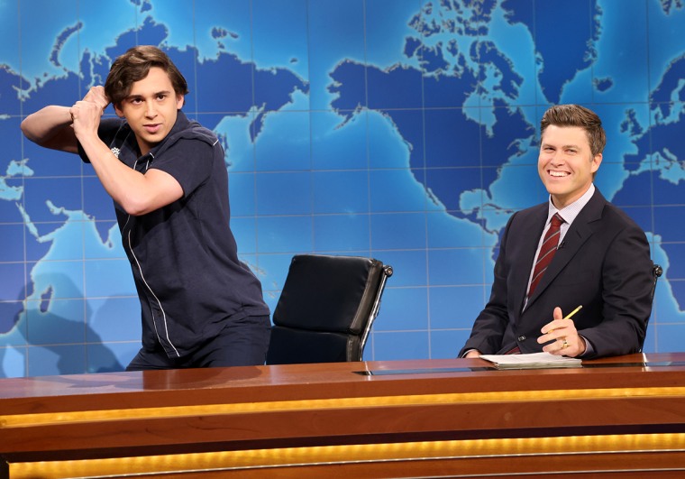 Marcello Hernandez and Colin Jost on set; Marcello pretends to swing a baseball bat 