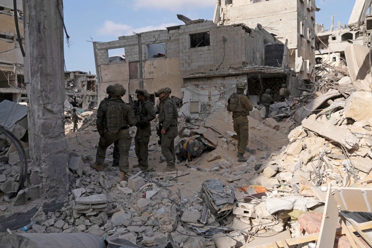 Israeli soldiers inspect Rafah's destroyed buildings.