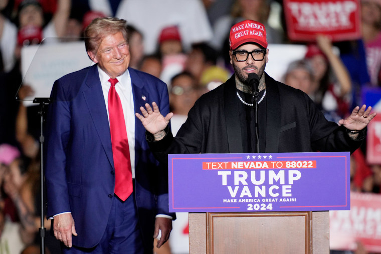 Donald Trump smiles as Nicky Jam speaks