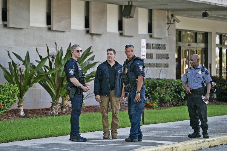 Security and law enforcement officials stand outside the Paul G. Rogers Federal Building and US Courthouse