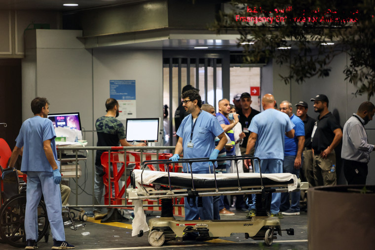 Hospital staff surrounding an empty stretcher