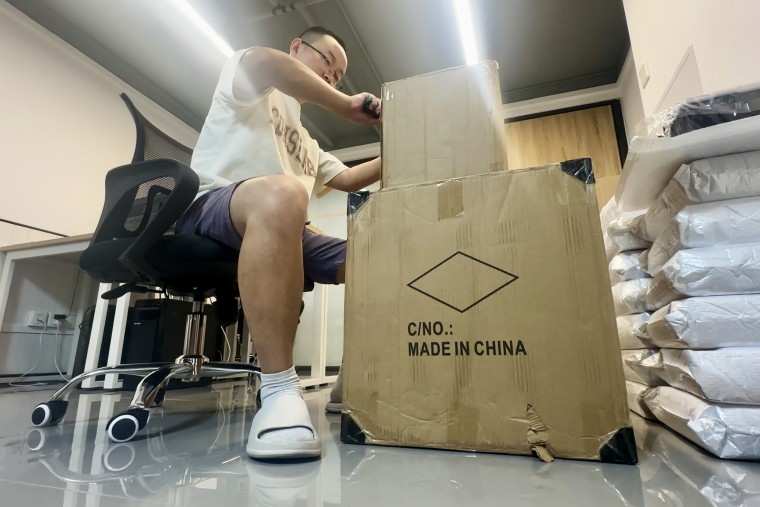 A Chinese seller unpacking a box of items he purchased to list on Temu in Shenzhen.