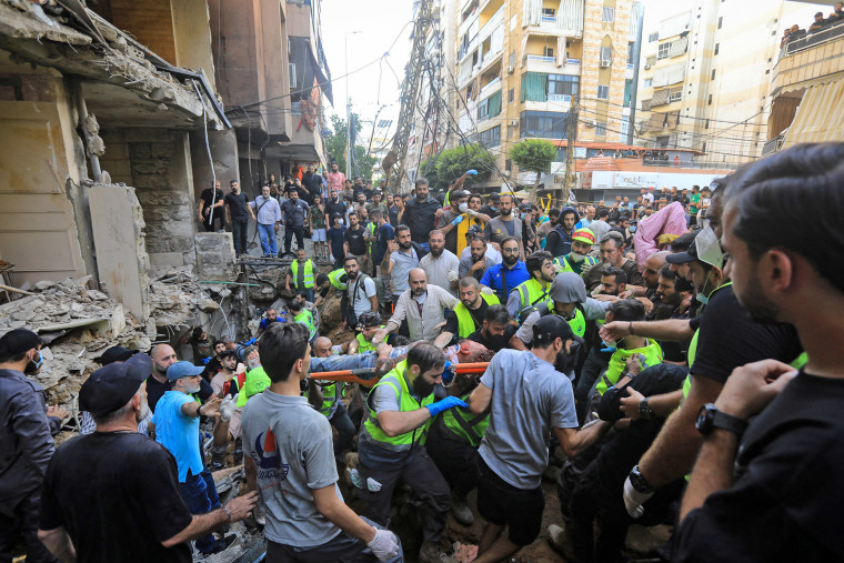 An injured man is evacuated from the scene of an Israeli strike in Beirut's southern suburbs on Sept. 20, 2024. 