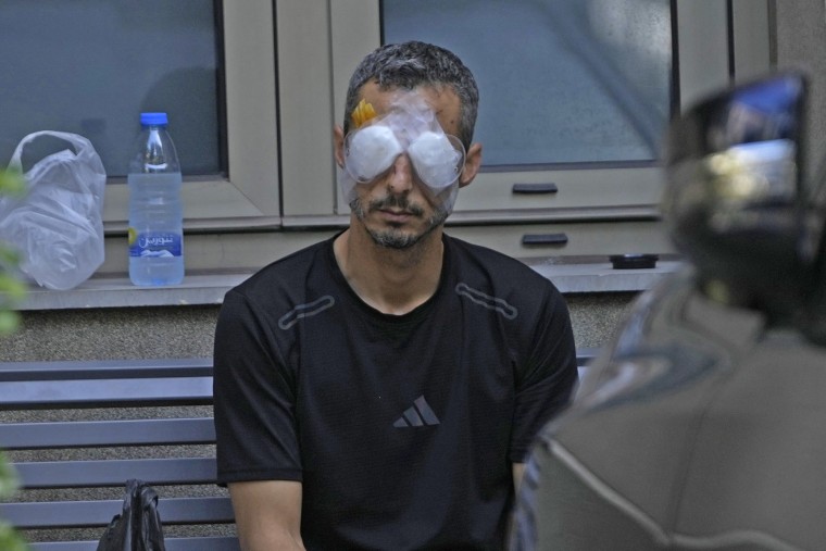 A man who was injured in the explosion of one of the handheld devices wears bandages over his eyes. 