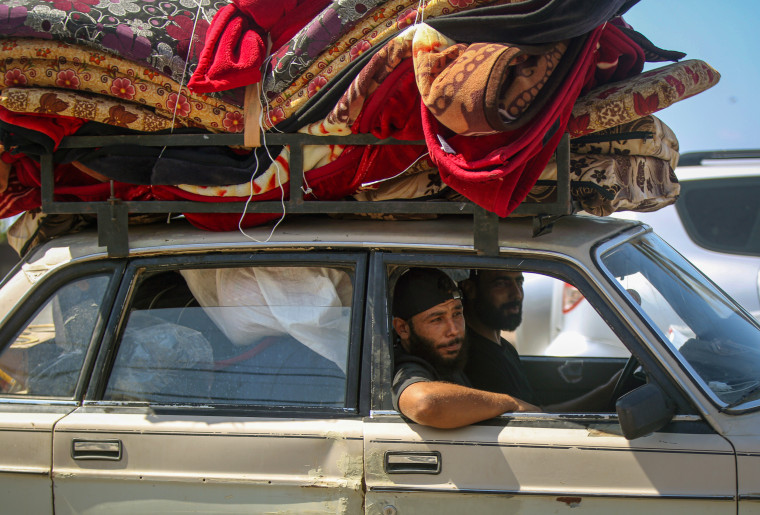 Lebanese drive a car loaded with belongings.