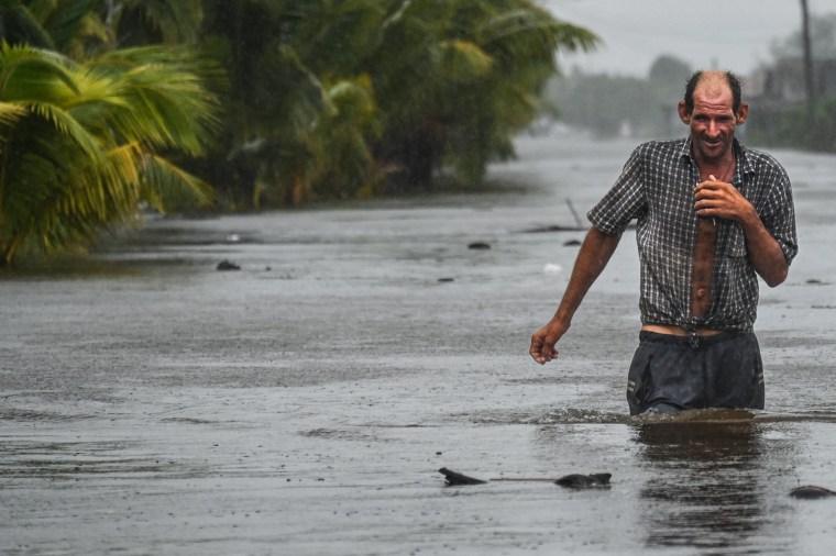 Un hombre camina en el agua durante un huracán.